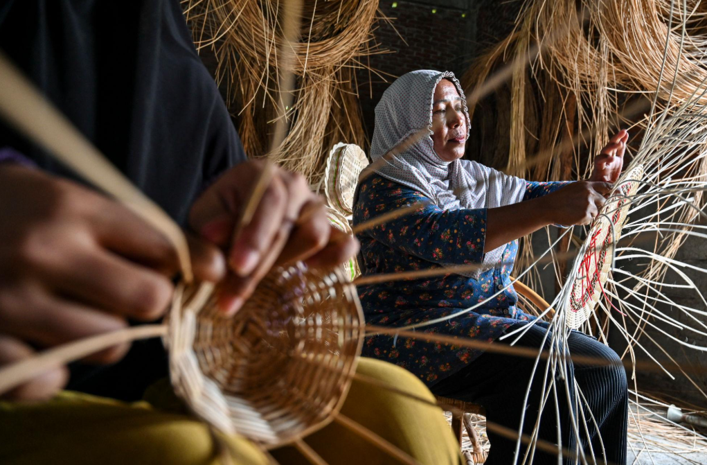Pengrajin PALMA ROTAN sedang menganyam rotan